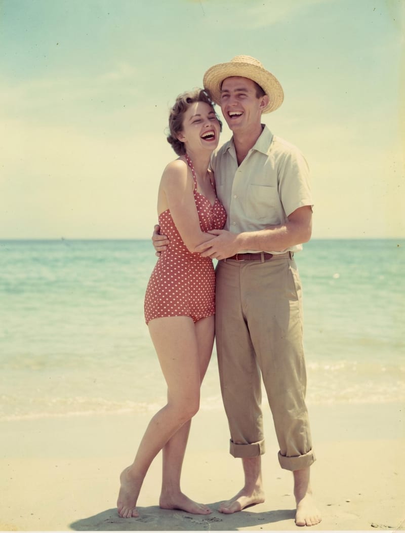 An old black-and-white 1962 photo of a young couple laughing together on a beach, colorized to full color